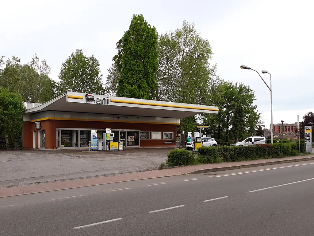 Un piccolo distributore di carburante lungo una strada alberata